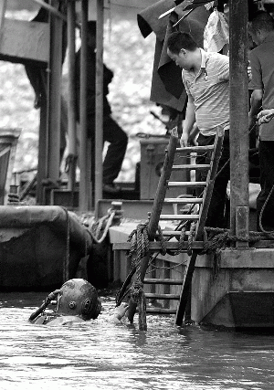 10日,在出事水域附近,一位进行搜救的潜水员浮出水面。新华社记者 李尕 摄